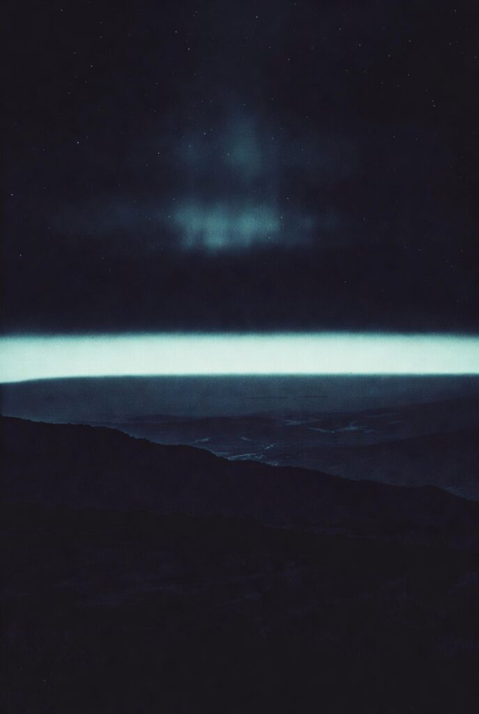 Representação simbólica da transição entre vida, consciência e o desconhecido, com horizonte escuro iluminado por luz distante e céu estrelado
