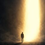 Figura humana entre la oscuridad y una luz dorada